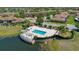 An aerial view of a community pool near a lake with a covered structure and landscaped surroundings at 10509 Belfry Cir, Orlando, FL 32832