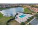 A shared community pool and jacuzzi are visible in the foreground, with a lake and residential units in the background at 10509 Belfry Cir, Orlando, FL 32832