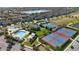 Aerial view of community tennis courts, swimming pool, playground, and beautiful landscaping at 10509 Belfry Cir, Orlando, FL 32832