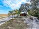 Aerial view of a red house with metal roof, green trees, and a long driveway at 111 Water Tank Rd, Haines City, FL 33844