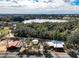 Aerial view of a property featuring a house and multiple outbuildings, with a lake in the background at 111 Water Tank Rd, Haines City, FL 33844