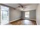 Bedroom with wood flooring, base trim, ceiling fan, and access to the tiled bathroom at 111 Water Tank Rd, Haines City, FL 33844