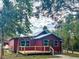 Front exterior of the home with a metal roof, new deck, and mature trees at 111 Water Tank Rd, Haines City, FL 33844