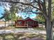 Exterior shot of a quaint red house with a welcoming porch and well-maintained front yard at 111 Water Tank Rd, Haines City, FL 33844