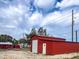 A charming red outbuilding, perfect for storage or a workshop, set against a backdrop of a beautiful blue sky at 111 Water Tank Rd, Haines City, FL 33844