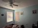 Bedroom with two windows and a ceiling fan for added comfort at 114 Langham Dr, Davenport, FL 33897