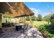 Outdoor patio area with shade covering, brick pavers, seating area, and lush landscaping at 11716 Astilbe Dr, Orlando, FL 32827