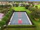 Aerial view of community basketball court surrounded by lush landscaping and mature trees at 11716 Astilbe Dr, Orlando, FL 32827