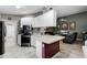 Modern kitchen with white cabinets, stainless steel appliances, and a peninsula counter, and a view to the living room at 11716 Astilbe Dr, Orlando, FL 32827