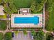 Aerial view of a community pool with lounge chairs, lush landscaping, and parking at 11716 Astilbe Dr, Orlando, FL 32827