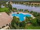 A clover-shaped pool has lounge chairs around it and palm trees blowing in the wind at 11716 Astilbe Dr, Orlando, FL 32827