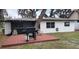 Backyard view featuring a deck, grill, screened porch, and well-maintained lawn at 11801 Lake Susan Ct, Clermont, FL 34711