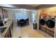 The dining area features modern lighting and a view of a stainless steel washer and dryer at 11801 Lake Susan Ct, Clermont, FL 34711