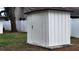 Exterior shot of a white storage shed in the backyard with a neutral privacy fence at 11801 Lake Susan Ct, Clermont, FL 34711