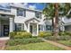 Inviting townhouse with lush landscaping, brick walkway, and palm trees enhancing curb appeal at 11867 Pulitzer Pl, Orlando, FL 32832