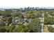 Aerial view of property featuring mature trees, a lake, and city skyline backdrop at 1508 Delaney Ave, Orlando, FL 32806