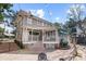 Back exterior featuring a covered porch with white railings and a brick patio with string lights at 1508 Delaney Ave, Orlando, FL 32806