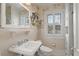 Bright bathroom with a pedestal sink, white tile, and window for natural light at 1508 Delaney Ave, Orlando, FL 32806