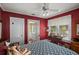 Bedroom with red walls, hardwood floors, ceiling fan, and natural light from a window at 1508 Delaney Ave, Orlando, FL 32806