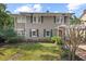 Inviting two-story home with awnings, a red front door, and lush landscaping at 1508 Delaney Ave, Orlando, FL 32806