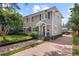 Attractive two-story home with a brick driveway, neat landscaping, and a charming red front door at 1508 Delaney Ave, Orlando, FL 32806