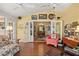 Cozy sunroom with hardwood floors, ceiling fans, and doorway to the formal dining room at 1508 Delaney Ave, Orlando, FL 32806