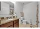 Well-lit bathroom with a toilet and a vanity featuring a granite countertop and matching hardware at 15506 Gemini Dr, Mascotte, FL 34753