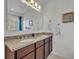 Bathroom featuring double sink vanity, granite countertop, and a large mirror at 15506 Gemini Dr, Mascotte, FL 34753