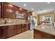 A kitchen with granite countertops, stainless steel appliances, and brown cabinets at 15506 Gemini Dr, Mascotte, FL 34753