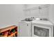 Clean laundry room featuring a large washer, dryer and storage shelving at 15506 Gemini Dr, Mascotte, FL 34753