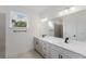 Bright bathroom featuring double sink vanity, large mirror, stone countertop, tiled floors and a window view at 1633 Sw 168Th Loop, Ocala, FL 34473