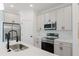 Modern kitchen with stainless appliances, sleek white countertops, gray cabinets, and a black faucet at 1633 Sw 168Th Loop, Ocala, FL 34473