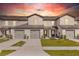 Townhome showcases a two-car garage, well-maintained landscaping, and exterior paint at 1703 Wynford Cir, Tavares, FL 32778