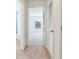 Bright hallway leading to a bedroom with a large window, showcasing the open floor plan at 1703 Wynford Cir, Tavares, FL 32778