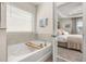 Relaxing bathroom featuring a soaking tub with a window and a peek into the bedroom at 18339 Oliver Twist Way, Winter Garden, FL 34787