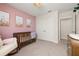 Bedroom with a crib, rocking chair, dresser, and pink accent wall at 18339 Oliver Twist Way, Winter Garden, FL 34787