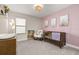 Charming Bedroom with pink accent wall, crib, rocking chair, and ample natural light at 18339 Oliver Twist Way, Winter Garden, FL 34787