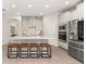 Modern kitchen with stainless steel appliances, white cabinets, a large island, and seating at 18339 Oliver Twist Way, Winter Garden, FL 34787