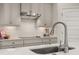 Close-up of kitchen with white backsplash, stainless steel sink, and modern appliances at 18339 Oliver Twist Way, Winter Garden, FL 34787