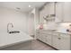 Bright kitchen featuring an island with sink, white cabinets, a white backsplash, and stainless steel appliances at 18339 Oliver Twist Way, Winter Garden, FL 34787