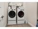 Modern laundry room equipped with a side-by-side washer and dryer and built in shelving at 18339 Oliver Twist Way, Winter Garden, FL 34787