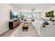 Spacious living room with large sectional sofa, modern decor, and plenty of natural light at 18339 Oliver Twist Way, Winter Garden, FL 34787