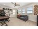 Bright office space with ample natural light, a comfortable sofa, and built-in shelving at 18339 Oliver Twist Way, Winter Garden, FL 34787