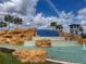 Beautiful community water feature with palm trees, rocks, and blue tile in the Waterleigh community at 18339 Oliver Twist Way, Winter Garden, FL 34787