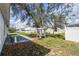 View of backyard featuring mature tree, patio, and weathered structure at 1909 Michigan Way, Poinciana, FL 34759