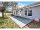 Spacious concrete patio overlooking the grassy backyard with white house exterior at 1909 Michigan Way, Poinciana, FL 34759