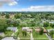 An aerial view of a neighborhood with tree-lined streets shows houses with well-maintained lawns and a distant city skyline at 23 Judith Ln, Orlando, FL 32811