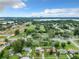 An aerial view shows a neighborhood with a lake, trees, and a distant city skyline under a blue, partly cloudy sky at 23 Judith Ln, Orlando, FL 32811