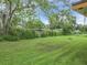 Large, grassy backyard featuring mature trees and a partial fence line at 23 Judith Ln, Orlando, FL 32811