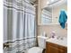 Bathroom with striped shower curtain, standard toilet and a wood vanity at 23 Judith Ln, Orlando, FL 32811